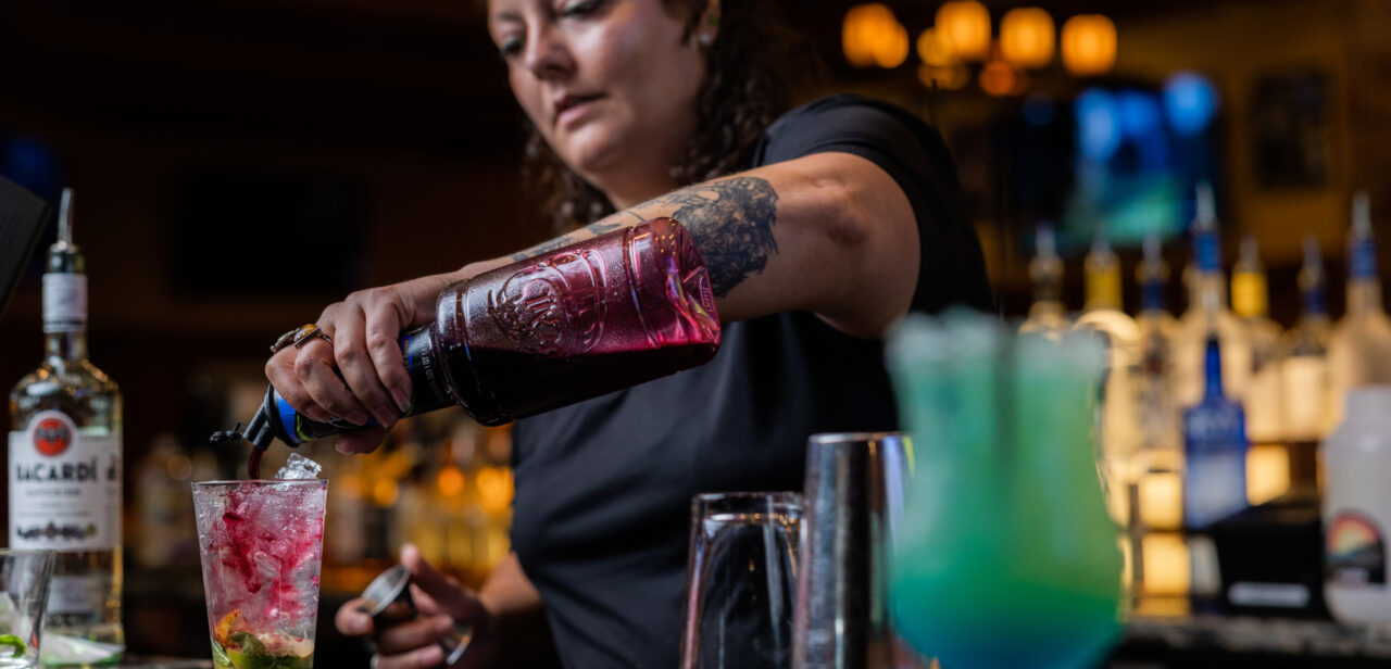 Bartender pouring a drink behind the counter